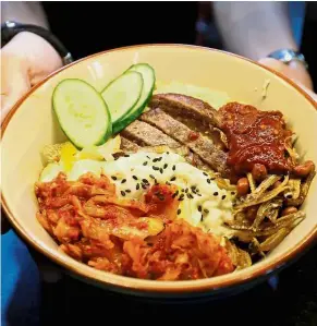  ?? — Reuters ?? Delicious twist: A bowl of Trump-Kim nasi lemak, made from dry-aged US beef and kimchi, at Harmony Nasi Lemak restaurant.