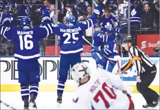  ?? Canadian Press photo ?? Toronto Maple Leafs centre Tyler Bozak (42) celebrates his goal against Washington Capitals goalie Braden Holtby (70) with Maple Leafs centre Nazem Kadri (43) as Mitch Marner and James van Riemsdyk look on during overtime NHL hockey round one playoff action in Toronto on Monday.