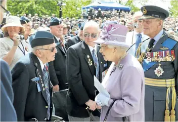  ?? JOHN STILLWELL/GETTY IMAGES ?? Queen Elizabeth and Prince Philip, Duke of Edinburgh speak with Second World War veteran Ed Carter-Edwards, a former member of Bomber Command from Canada, after unveiling the Bomber Command Memorial at Green Park in June 2012 in London, England.