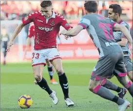  ?? FOTO: V. LLURBA ?? El local Salva intenta conducir el balón rodeado de jugadores del Granada