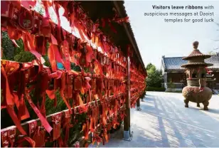  ??  ?? Visitors leave ribbons with auspicious messages at Daoist temples for good luck