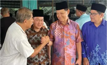  ?? ?? Mohamaddin (second right) exchanging greetings with those who attended the open house.