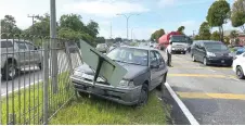  ??  ?? The car landed on the road divider at Mile 17 Jalan Kuching-Serian after the driver was believed to have suffered a cardiac arrest.