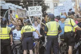  ?? STAFF PHOTOS BY NANCY LANE, TOP, AND NICOLAUS CZARNECKI, ABOVE ?? ‘STANDING TALL’: Counterpro­testers march from Roxbury yesterday to Boston Common, top, where police, above, maintained control.