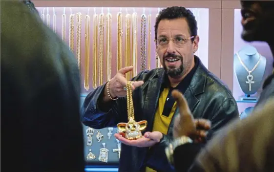  ?? A24 Pictures ?? Who wants a diamond-encrusted Furby necklace? Adam Sandler as Howard Ratner is under the impression that basketball star Kevin Garnett might.