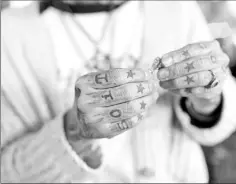  ??  ?? Tattoos displayed on the fingers of a tattoo artist at a studio in Shanghai.