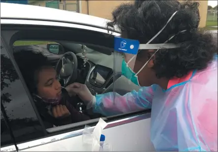  ?? RICHARD PAYERCHIN — THE MORNING JOURNAL ?? Lorain school nurse Marla Davis uses a swab for a COVID-19test for Amaya Smith, 12, a seventh-grade student at General Johnnie Wilson Middle School. On Oct. 20, Lorain City Schools had its third day of drive-up testing at George Daniel Field for student-athletes and those who will participat­e in close-contact activities. Amaya said she plans to play basketball for her school.