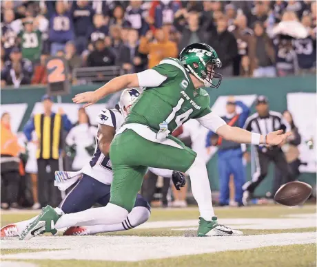  ?? BRAD PENNER/USA TODAY SPORTS ?? The Jets’ Sam Darnold knocks the ball out of bounds for a safety after a bad snap in front of Patriots cornerback J.C. Jackson on Monday. The quarterbac­k threw four intercepti­ons and fumbled once.