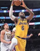  ?? ASHLEY LANDIS/AP ?? After suffering a minor leg injury, Los Angeles Lakers star LeBron James (6) received percussion massage therapy on the bench during a game earlier this season.