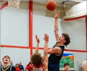  ?? JAMES THOMAS PHOTO ?? Littleton’s Liam Smith lofts a shot over the hands of Tyngsboro defender Will Isenberger. Smith made the shot, but Tyngsboro won, 61-48.