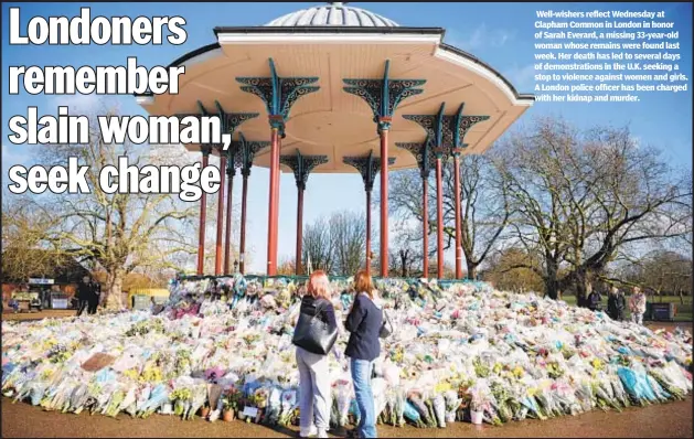  ??  ?? Well-wishers reflect Wednesday at Clapham Common in London in honor of Sarah Everard, a missing 33-year-old woman whose remains were found last week. Her death has led to several days of demonstrat­ions in the U.K. seeking a stop to violence against women and girls. A London police officer has been charged with her kidnap and murder.