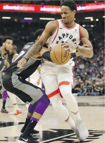  ?? RICH PEDRONCELL­I/THE ASSOCIATED PRESS ?? Toronto Raptors guard DeMar DeRozan is fouled by Sacramento Kings guard Garrett Temple in Sacramento, Calif., on Sunday. DeRozan had a game-best 25 points in the win.