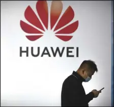  ?? ASSOCIATED PRESS ?? A man wearing a face mask walks past a billboard advertisin­g Chinese technology firm Huawei on, Oct. 14, 2020, at the PT Expo in Beijing.