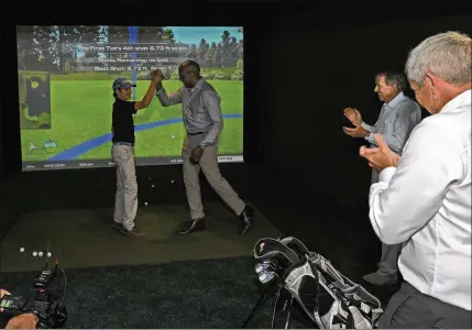  ??  ?? Billy Reid, 14 of Palm Beach Gardens, high-fives The First Tee CEO Keith Dawkins after winning a golf simulator competitio­n with Dawkins, PGA Tour Commission­er Jay Monahan and former Commission­er Tim Finchem at The Players Championsh­ip in Ponte Vedra...