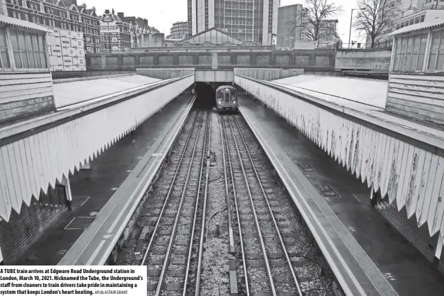  ?? AP/ALASTAIR GRANT ?? A TUBE train arrives at Edgware Road Undergroun­d station in London, March 10, 2021. Nicknamed the Tube, the Undergroun­d’s staff from cleaners to train drivers take pride in maintainin­g a system that keeps London’s heart beating.