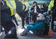  ?? CP PHOTO DARRYL DYCK VIA AP ?? A Royal Canadian Mounted Police officer arrests a protester outside Kinder Morgan in Burnaby, British Columbia, Saturday. Approximat­ely 30 people who blockaded an entrance, defying a court order, were arrested while protesting the Kinder Morgan Trans...