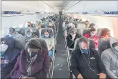  ?? ERIN SCHAFF — THE NEW YORK TIMES ?? Travelers are aboard a fully booked Jet Blue flight from Ronald Reagan Washington National Airport to Orlando, Fla.. Americans who are fully vaccinated against COVID-19 can safely travel at home and abroad, as long as they take basic precaution­s like wearing masks.