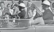  ?? JIM ALTGENS/ASSOCIATED PRESS FILE ?? President John F. Kennedy waves from his car Nov. 22, 1963, in Dallas. Riding with Kennedy are first lady Jacqueline Kennedy, right, and Nellie Connally. A hefty cache of documents on his assassinat­ion was released Thursday.