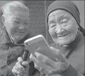  ?? SI WEI / FOR CHINA DAILY ?? A 114-year-old woman surfs the internet using her cellphone in Lianyungan­g, Jiangsu province, last year.