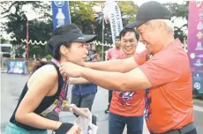  ?? ?? Borneo Half Marathon women’s 21km Open winner Lavinia receiving her medal from Mayor Datuk Seri Dr Sabin Samitah.