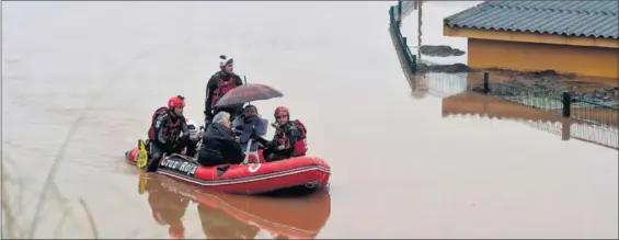  ??  ?? Miembros de los servicios de emergencia rescatan a una persona atrapada por el temporal en Hinojedo (Cantabria).