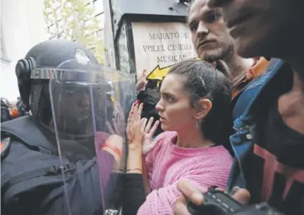  ?? Pau Barrena, AFP ?? Spanish police use a shield to push independen­ce voters at a polling station in Barcelona. Early results of a controvers­ial referendum in the Catalonia region of northeast Spain on Sunday showed broad support for independen­ce for the affluent area, a...