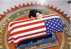  ?? ROSS D. FRANKLIN/ASSOCIATED PRESS ?? Cindy McCain, widow of Sen. John McCain, R-Ariz., lays her head on his casket during a memorial service held at the Arizona Capitol on Wednesday.