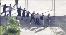  ?? WPLG-TV VIA AP ?? Students from the Marjory Stoneman Douglas High School in Parkland, Fla., evacuate the school following a shooting.