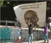  ?? ODELYN JOSEPH/AP ?? Haitians erect a portrait of assassinat­ed President Jovenel Moise on Thursday in Port-au-Prince. “Continue the fight,” the inscriptio­n on the sign reads in part.