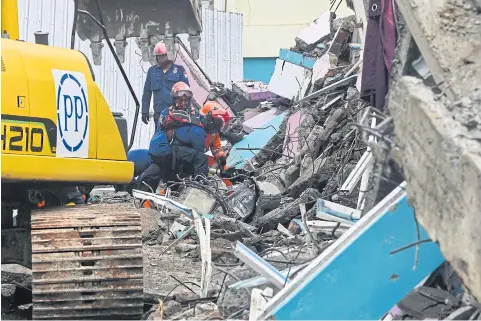  ?? AFP ?? Members of a search and rescue team look for people trapped in the rubble at Mitra Manakarra hospital in Mamuju yesterday.