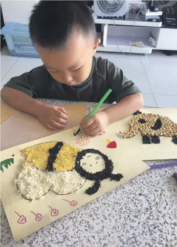  ?? Li Ke ?? Tu Tu, who is four, uses his left hand. His father is determined that the weight of old negative notions of left-handers, passed down the generation­s, will not burden his son