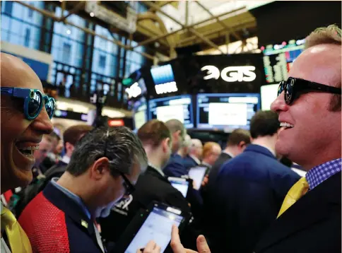  ?? (Reuters) ?? INVESTORS LAUGH while wearing Snapchat glasses on the floor of the New York Stock Exchange as they wait for Snap Inc. to post its IPO earlier this month.