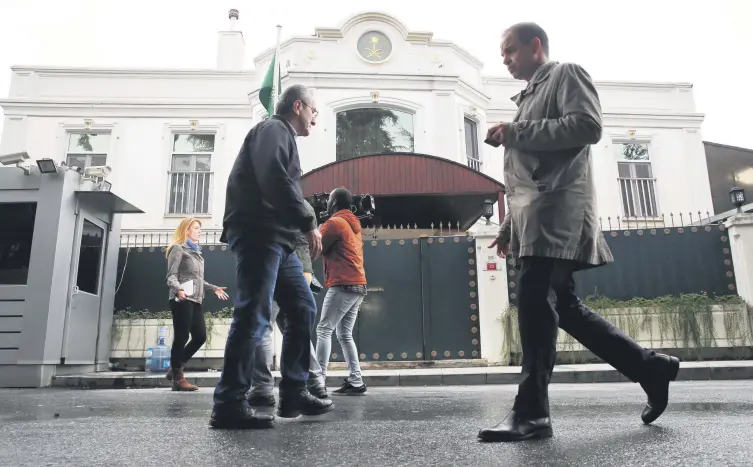  ??  ?? Pedestrian­s walk by as members of the media report from outside of Saudi Arabia’s consul general’s residence in Istanbul, Oct. 18.