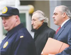  ?? DANIEL ACKER / BLOOMBERG FILES ?? The financial damage done by Bernard Madoff, centre, continues to this day, say victims of his Ponzi-style fraud.
