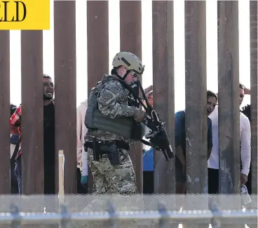  ?? GREG BULL / THE ASSOCIATED PRESS ?? A U.S. Customs and Border Protection officer walks along a barrier at the Mexico-U.S. border, in San Diego, Calif., on Sunday. Migrants attempted to penetrate several points along the border.
