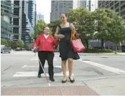  ?? JOHN J. KIM/CHICAGO TRIBUNE ?? Ann Brash, left, who was part of a group who sued the city for the developmen­t of audible crosswalk signals, walks with assistance from attorney Jelena Kolic in Chicago in 2019.