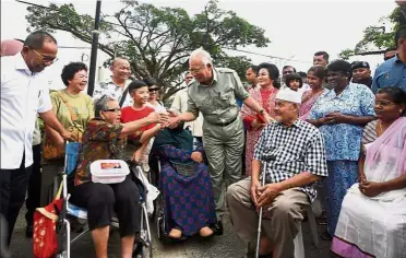  ?? — Bernama ?? Jovial conversati­on: Najib and Rosmah greeting people during their ‘Kongsi Kasih’ visit to the Sultan Haji Ahmad Shah Convention­al Hall in Pekan.