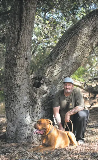  ?? Sara Gobets / Special to The Chronicle ?? Former Navy medic Chris Woolf, with his mastiff, Sir Anthony Brutus Brewcephus II, ignored evacuation orders in Brush Creek (Butte County) and barely escaped with his sister.