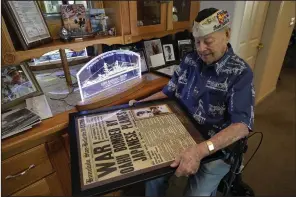  ?? (AP/Rich Pedroncell­i) ?? Pearl Harbor survivor Lou Conter holds a framed replica of the Honolulu Star-Bulletin of Dec. 7, 1941, at his home in Grass Valley, Calif., in November 2022.