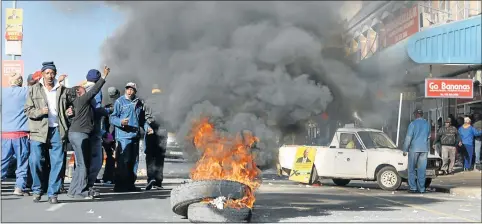  ?? Picture: BHONGO JACOB ?? SCENE OF UNREST: Tyres are set alight in Cathcart Road as protest action by municipal workers drags on