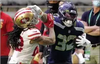  ??  ?? D
Seattle Seahawks running back Chris Carson stiff arms 49ers cornerback Jason Verrett during the first half on Sunday.