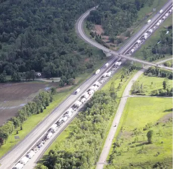  ?? LARS HAGBERG/ THE CANADIAN PRESS ?? Traffic sits backed up in the westbound lanes of Highway 401 after a bus crashed into a rock cut along the highway in Prescott on Monday. One man died while four are still in hospital.