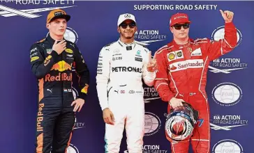  ??  ?? The top guys: Mercedes’ Lewis Hamilton (centre) posing after taking pole position for the Malaysia Grand Prix yesterday. Ferrari’s Kimi Raikkonen (right) will start from second and Red Bull’s Max Verstappen from third on the grid.