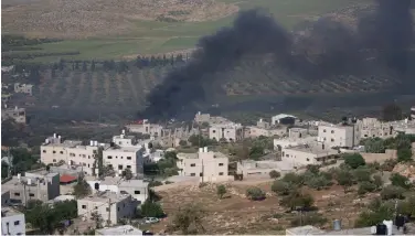  ?? ?? Smoke rises from Palestinia­n properties in the West Bank village of al-Mughayyir set ablaze by Israeli settlers