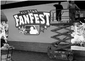  ?? JOE CAVARETTA/STAFF PHOTOGRAPH­ER ?? Workers hang giant video displays at the Miami Beach Convention Center for FanFest, part of the All-Star festivitie­s.