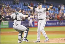  ?? Tom Szczerbows­ki / Getty Images ?? James Paxton is congratula­ted by catcher Mike Zunino after throwing the sixth no-hitter in Mariners franchise history.