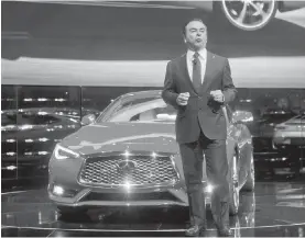  ?? TONY DING, THE ASSOCIATED PRESS ?? Carlos Ghosn, chairman and CEO of Nissan Motors, talks about the new Infiniti Q60 sports coupe behind him on stage at the show.