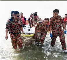  ?? — Bernama ?? ra ret rn The body the 11 year old boy being carried ashore by the Labuan fire and rescue personnel.