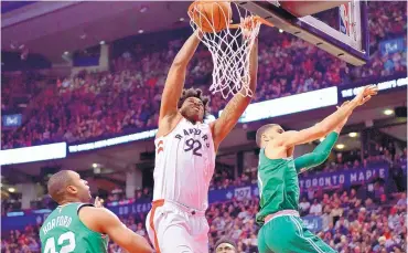  ?? FRANK GUNN/ASSOCIATED PRESS ?? Toronto center Lucan Nogueira (92) dunks between Boston’s Al Horford, left, and Jayson Tatum during the second half of the Raptors’ win over the Celtics on Wednesday night.