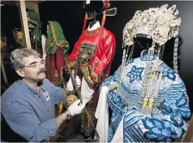  ??  ?? Objects curator George Field with a 1940s Chinese violin and opera costumes, part of the Free Spirit: Stories of You, Me and B.C. exhibit.